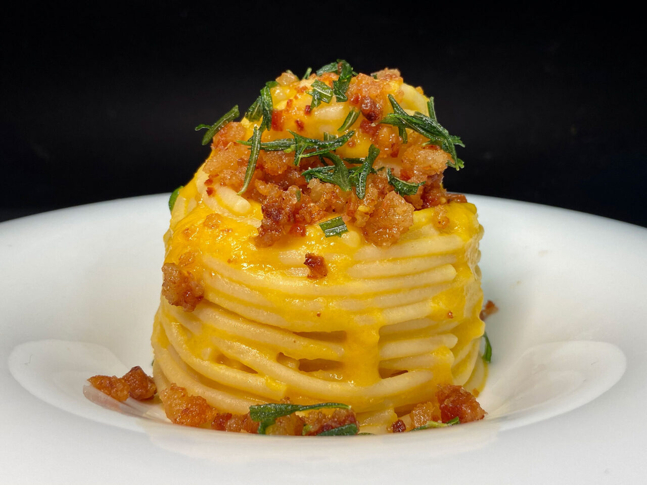 Spaghettone con crema di zucca, polvere di guanciale e rosmarino croccante