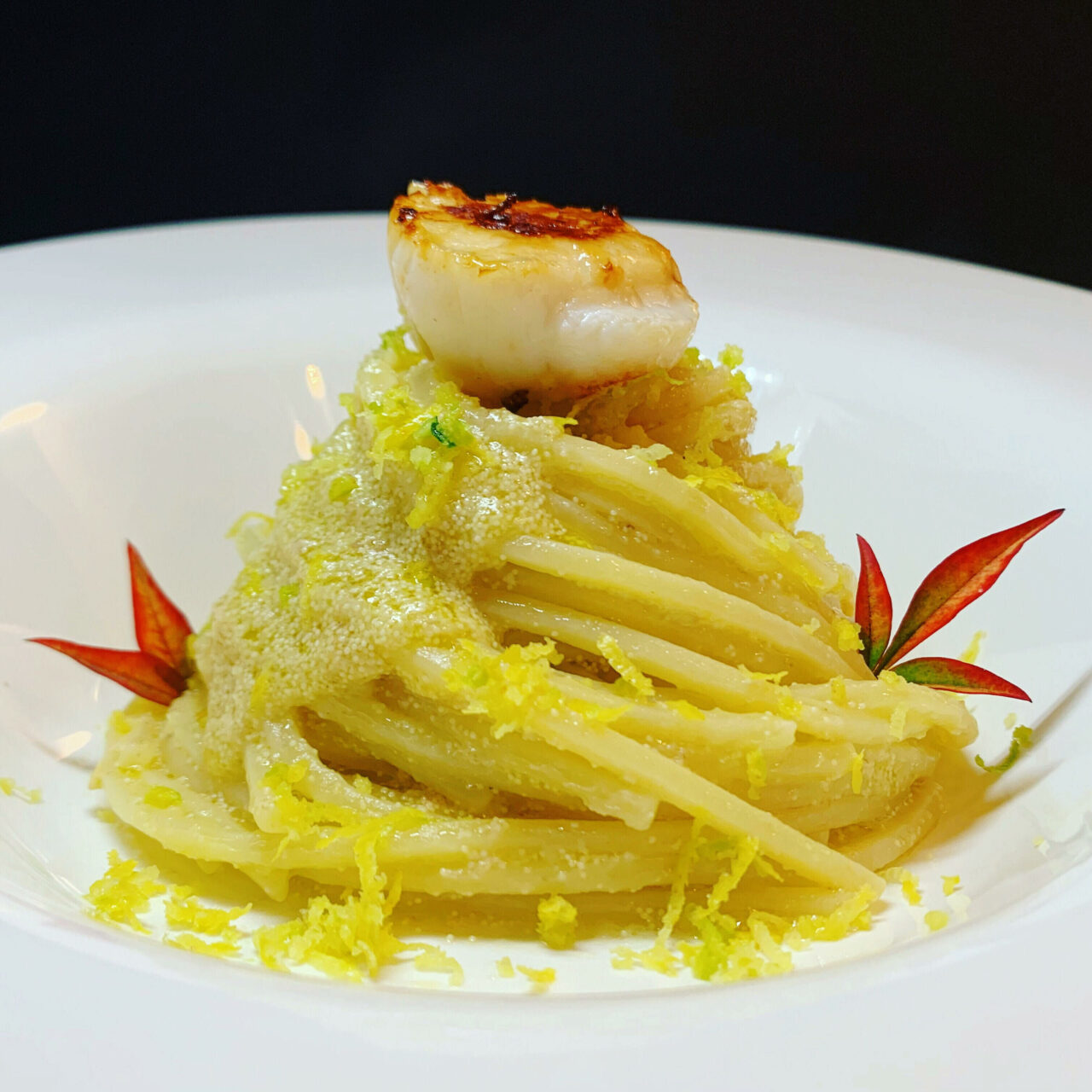 Spaghetti con uova di pesce, capesante scottate e limone