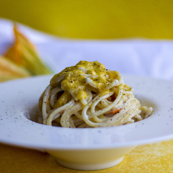 Spaghetti al pesto di fiori di zucca, acciughe e crema di Parmigiano