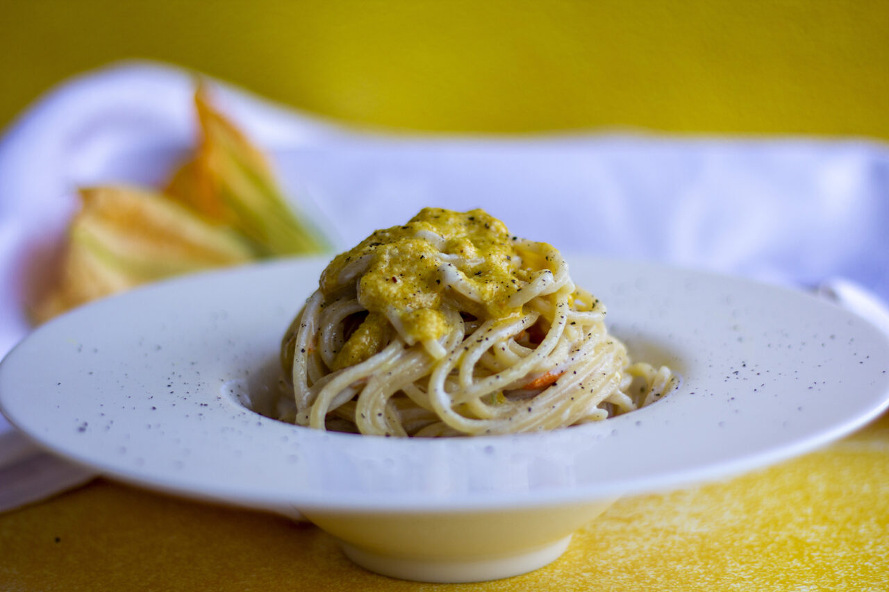 Spaghetti al pesto di fiori di zucca, acciughe e crema di Parmigiano