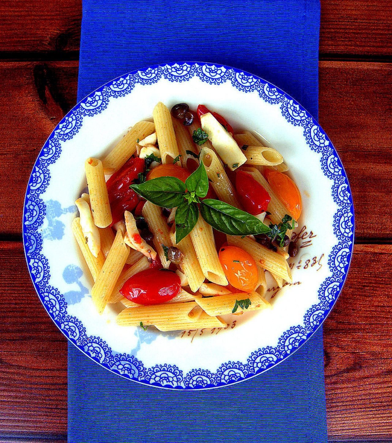 Die glutenfreie Penna mit Tintenfisch, roten und gelben Tomaten und Kapern