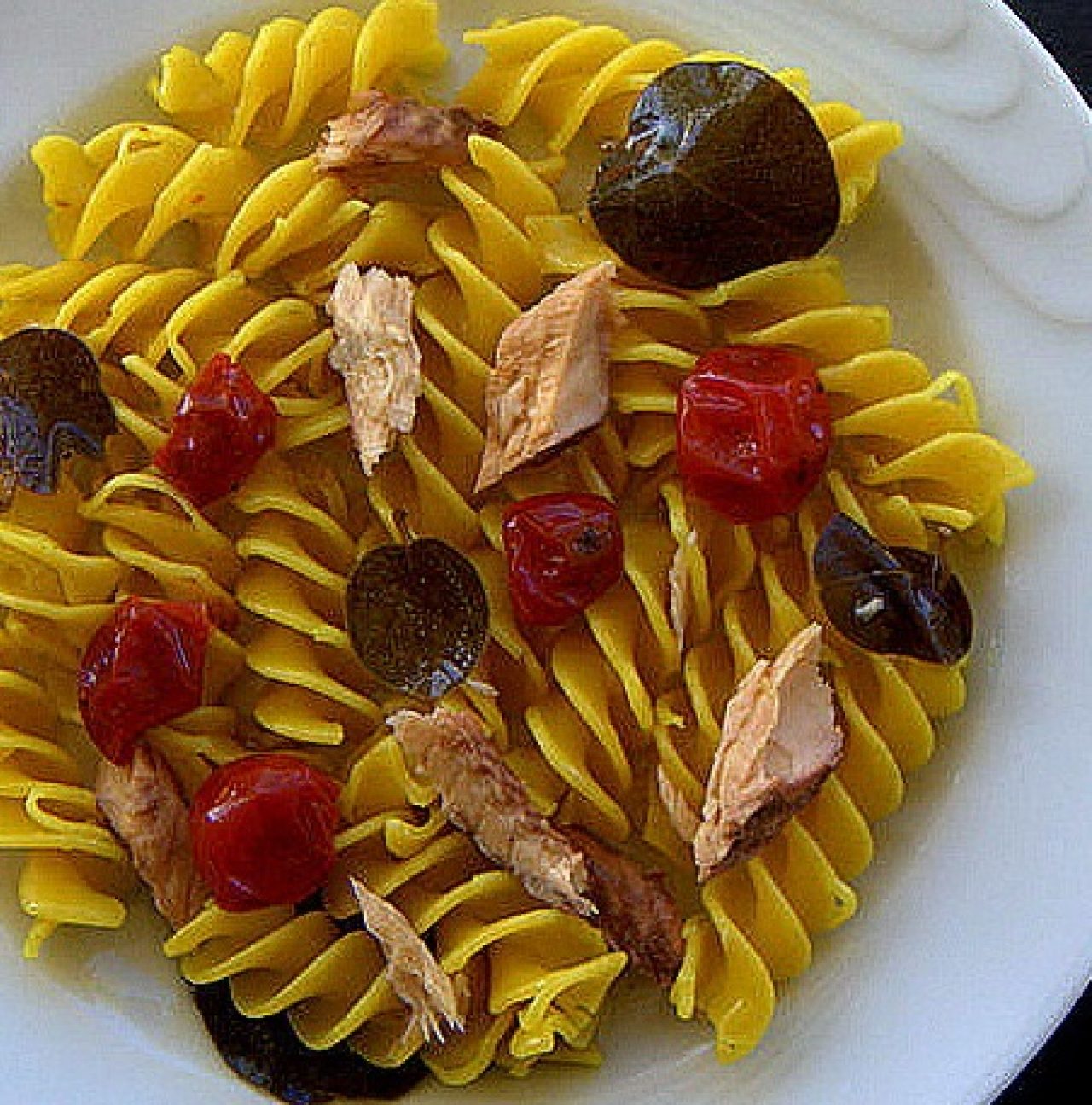 Gelbe Fusillone mit Makrele, konfierten Kirschtomaten und Kapernblättern in Olivenöl