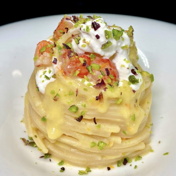 Chitarra mit gelben Datterini-Tomaten, Garnelen, Burrata-Käse und Pistazien.