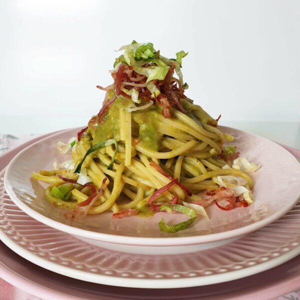 Chitarra con crema di fave e pomodorini secchi, porro e speck croccanti