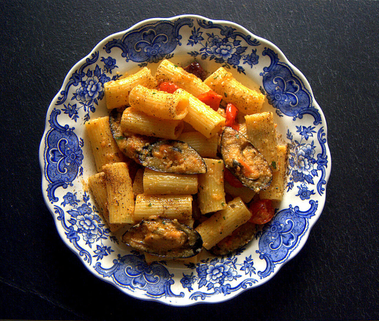 Rigatoni con pomodorini al forno, cozze gratinate e polvere di capperi