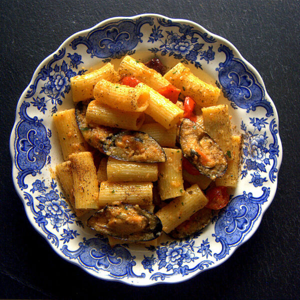 Rigatoni con pomodorini al forno, cozze gratinate e polvere di capperi